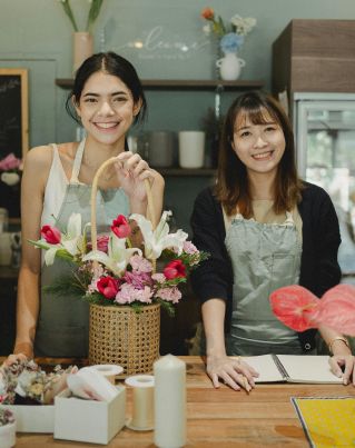 Smiling florists standing at counter in floristry shop